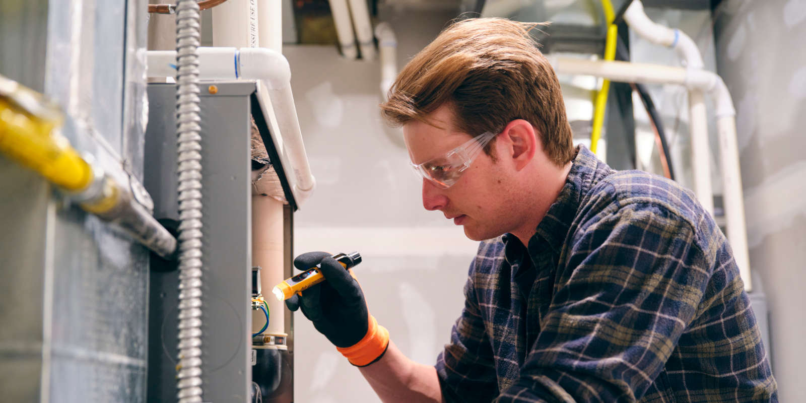 HVAC technician working basement equipment